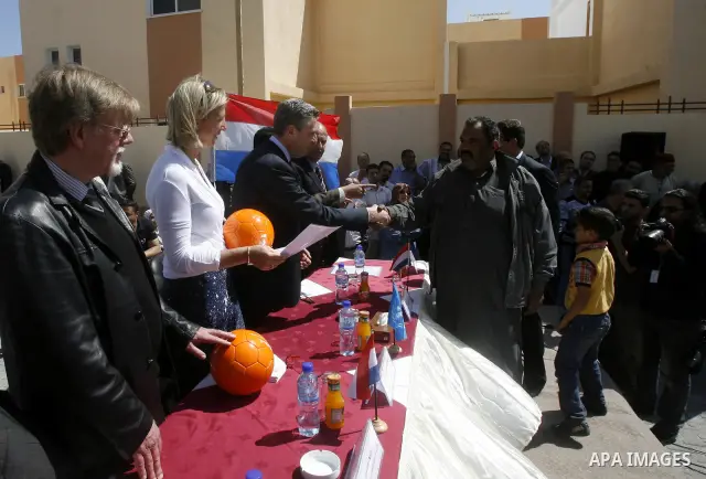 Birgitta Tazelaar, head of Mission of the Netherlands Representation to the Palestinian Authority, watches a Palestinian man react during a ceremony distributing new homes in Khan Younis in the southern Gaza Strip April...