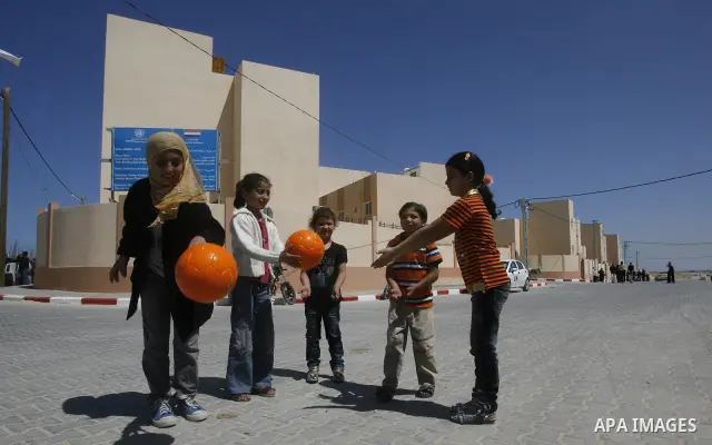 Palestinians Children play during a ceremony distributing new homes in Khan Younis in the southern Gaza Strip April 24, 2012. Palestinians, whose houses were destroyed during Israeli military operations in 2004 and 2005,...