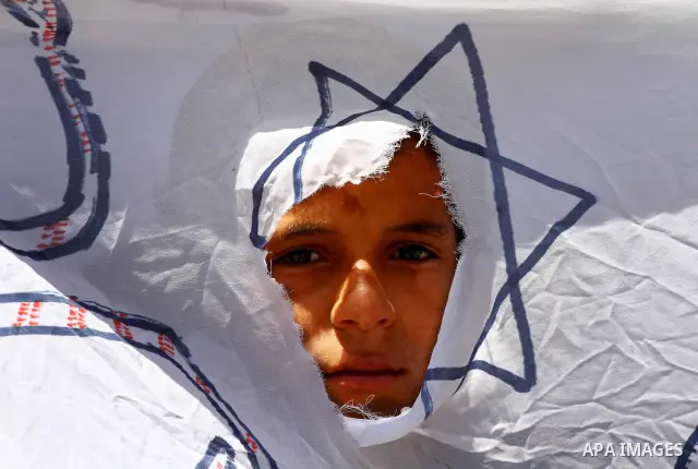 Egyptian child, wave a poster during a protest at Tahrir Square in Cairo, Egypt on April 25, 2012. Several thousand Egyptians are protesting against the country's military rulers. Photo by Ashraf Amra