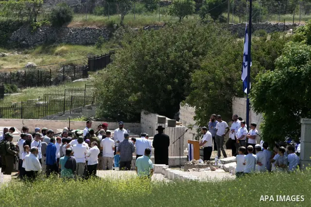 Israeli settler stands during pray in front of a Jewish cemetery near the settlement of Tel Rumeida, in the West Bank City of Hebron, on April 25, 2012. Photo by Mamoun Wazwaz