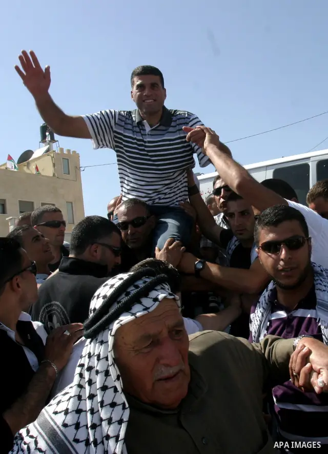 Palestinians celebrate the release of Tawfiq Iwisaat following his release from Israeli jail after 18 years of imprisonment in the Arab east Jerusalem neighbourhood of Jabal Mukaber on April 25, 2012. Photo by Mahfouz Ab...