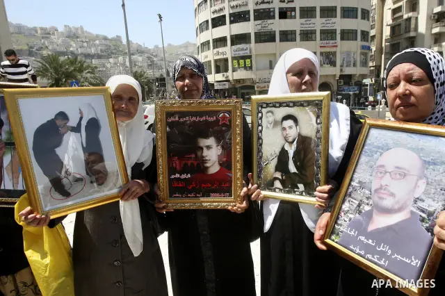 Palestinians hold up portraits of prisoners jailed in Israel during a demonstration calling for their release, in the West Bank city of Nablus on April 25, 2012. Photo by Wagdi Eshtayah