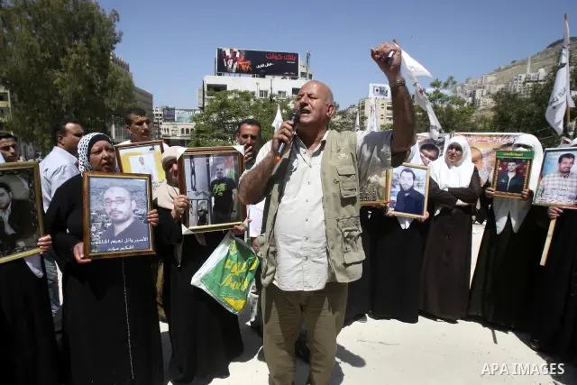 Palestinians hold up portraits of prisoners jailed in Israel during a demonstration calling for their release, in the West Bank city of Nablus on April 25, 2012. Photo by Wagdi Eshtayah