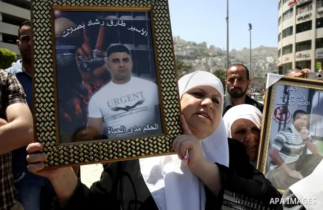 Palestinians hold up portraits of prisoners jailed in Israel during a demonstration calling for their release, in the West Bank city of Nablus on April 25, 2012. Photo by Wagdi Eshtayah