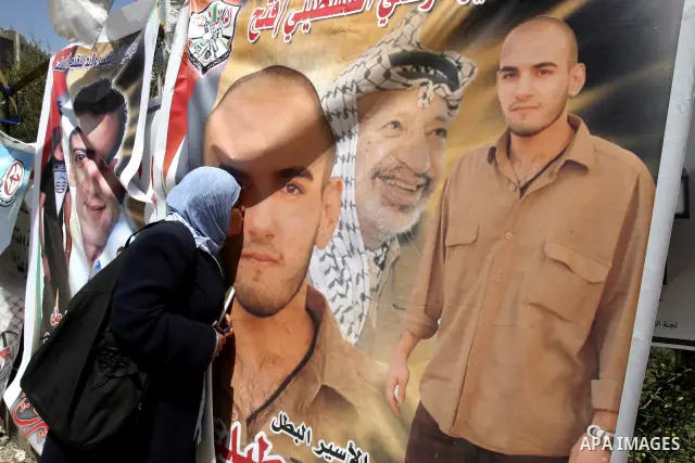 Palestinian woman kiss a portrait for a prisoner jailed in Israel during a demonstration calling for their release, in the West Bank city of Nablus on April 25, 2012. Photo by Wagdi Eshtayah