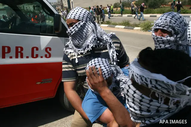 Palestinians carry a wounded demonstrator injured during clashes with Israeli soldiers at the Bitwonia crossing outside the Israeli military prison of Ofer, on Israel's 64th Independence Day, 26 April 2012. Palestinians...