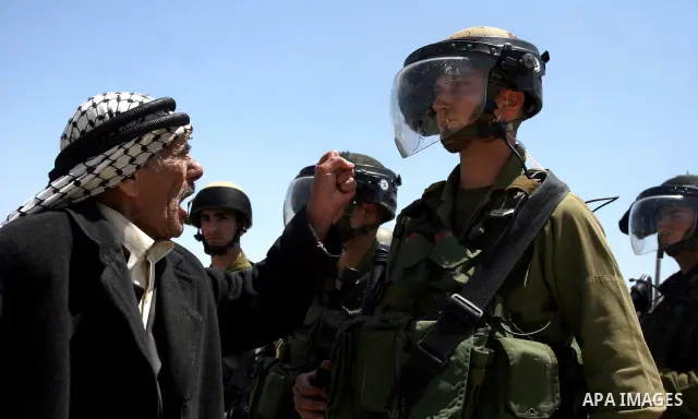 Palestinian old man shouts slogans for an Israeli soldier during clashes with Israeli soldiers at the Bitwonia crossing outside the Israeli military prison of Ofer, on Israel's 64th Independence Day, 26 April 2012. Pales...