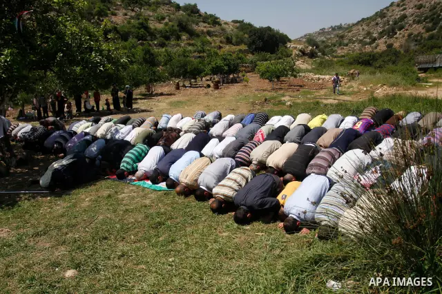 Palestinians pray during a protest against land confiscation by nearby Jewish settlements, Wadi Qana, in the West Bank village Deir Istia , Friday, April 27, 2012 . Photo by Wagdi Eshtayah