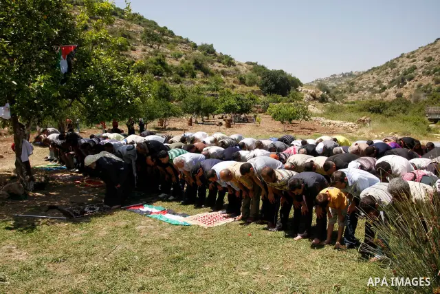 Palestinians pray during a protest against land confiscation by nearby Jewish settlements, Wadi Qana, in the West Bank village Deir Istia , Friday, April 27, 2012 . Photo by Wagdi Eshtayah