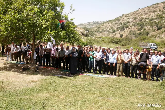 Palestinians pray during a protest against land confiscation by nearby Jewish settlements, Wadi Qana, in the West Bank village Deir Istia , Friday, April 27, 2012 . Photo by Wagdi Eshtayah
