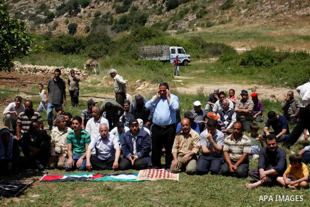 Palestinians pray during a protest against land confiscation by nearby Jewish settlements, Wadi Qana, in the West Bank village Deir Istia , Friday, April 27, 2012 . Photo by Wagdi Eshtayah