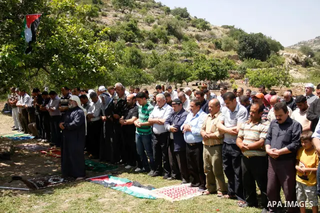 Palestinians pray during a protest against land confiscation by nearby Jewish settlements, Wadi Qana, in the West Bank village Deir Istia , Friday, April 27, 2012 . Photo by Wagdi Eshtayah