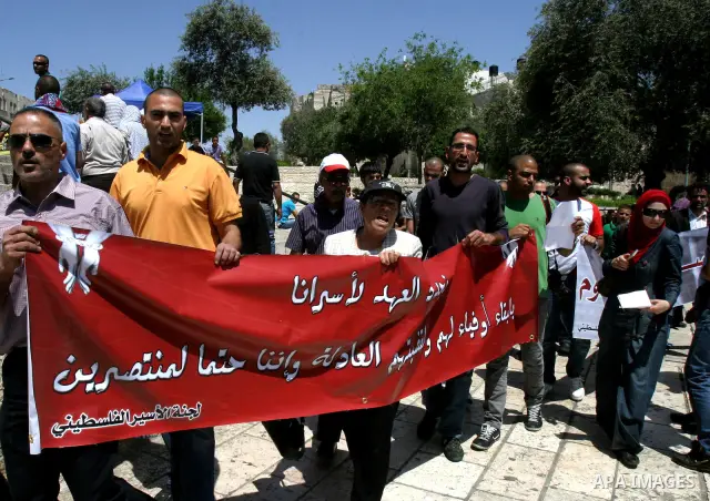 Palestinians hold portraits of relatives jailed in Israeli prisons as they protest to demand for their release, in the Al Aqsa Mosque compound in Jerusalem's Old City, on April 27, 2012. After decades of shying away from...