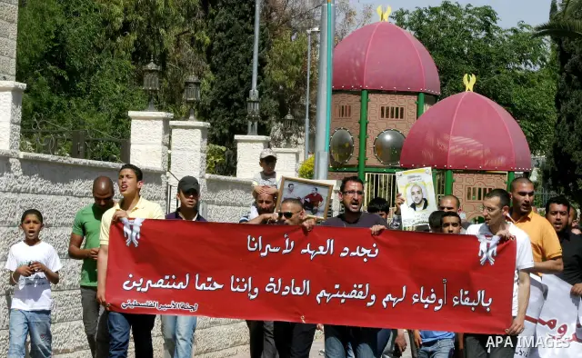 Palestinians hold portraits of relatives jailed in Israeli prisons as they protest to demand for their release, in the Al Aqsa Mosque compound in Jerusalem's Old City, on April 27, 2012. After decades of shying away from...
