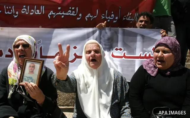 Palestinians hold portraits of relatives jailed in Israeli prisons as they protest to demand for their release, in the Al Aqsa Mosque compound in Jerusalem's Old City, on April 27, 2012. After decades of shying away from...
