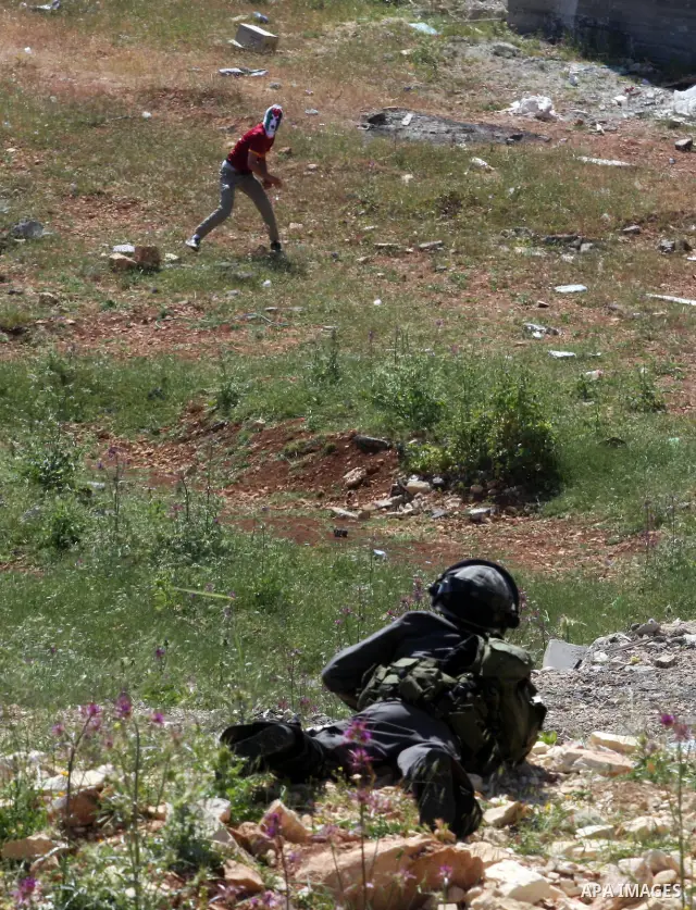 Palestinian youths and Israeli troops clash during a weekly demonstration against the expansion of the nearby Jewish settlement of Halamish in the West Bank village of Nabi Saleh near Ramallah, Friday, April 27, 2012. Ph...