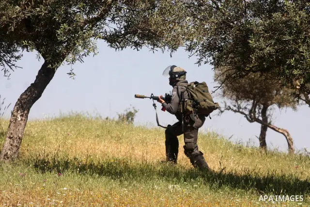 Palestinian youths and Israeli troops clash during a weekly demonstration against the expansion of the nearby Jewish settlement of Halamish in the West Bank village of Nabi Saleh near Ramallah, Friday, April 27, 2012. Ph...