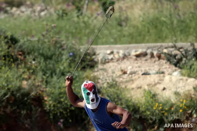 Palestinian youths and Israeli troops clash during a weekly demonstration against the expansion of the nearby Jewish settlement of Halamish in the West Bank village of Nabi Saleh near Ramallah, Friday, April 27, 2012. Ph...