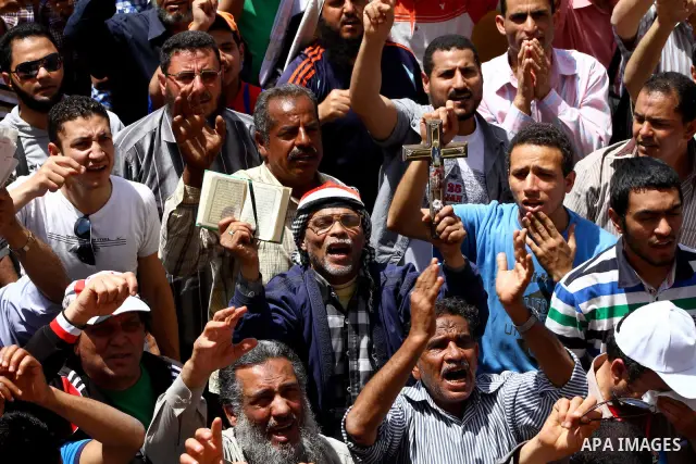 People attend Friday prayers in Tahrir Square in Cairo April 27, 2012. Tens of thousands of Egyptians demanded on Friday that their military rulers stick to a pledge to hand over power by mid-year after a row over who ca...
