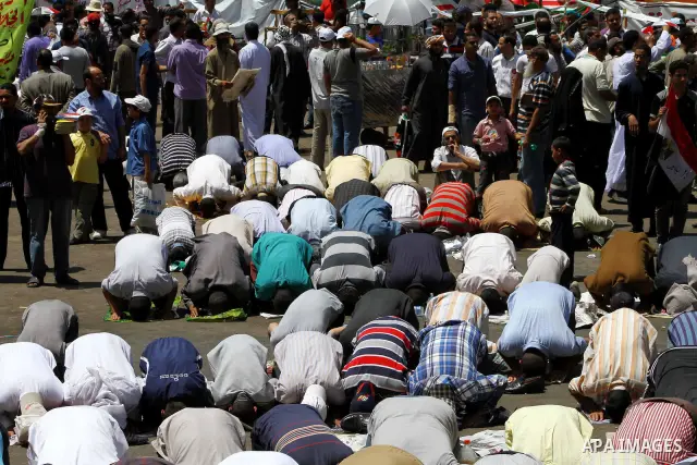 People attend Friday prayers in Tahrir Square in Cairo April 27, 2012. Tens of thousands of Egyptians demanded on Friday that their military rulers stick to a pledge to hand over power by mid-year after a row over who ca...