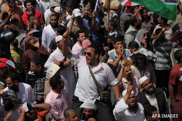 People attend Friday prayers in Tahrir Square in Cairo April 27, 2012. Tens of thousands of Egyptians demanded on Friday that their military rulers stick to a pledge to hand over power by mid-year after a row over who ca...