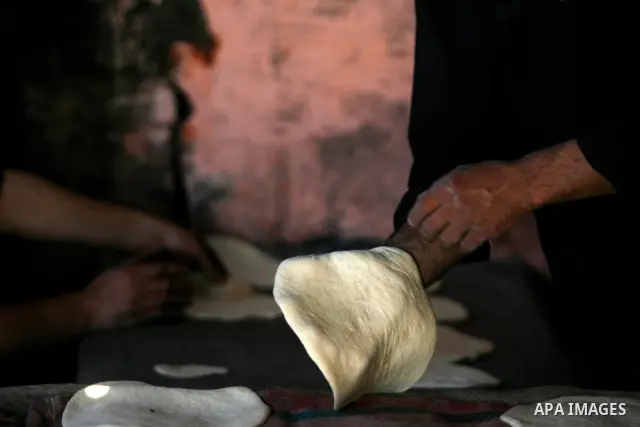 A Palestinian man bakes loaves of bread in a traditional mud oven in Rafah refugee camp, southern Gaza Strip on April 28, 2012. Photo by Eyad Al Baba