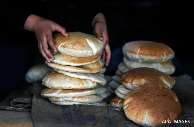 A Palestinian man bakes loaves of bread in a traditional mud oven in Rafah refugee camp, southern Gaza Strip on April 28, 2012. Photo by Eyad Al Baba