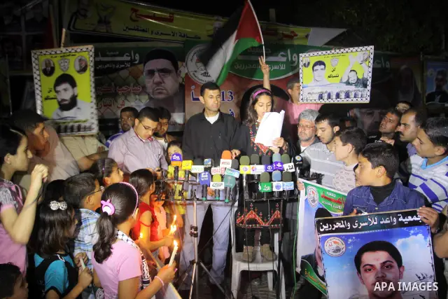 Palestinian children light candles during a rally in Gaza City to show solidarity with Palestinian prisoners held in Israeli jails, April 28, 2012. Human rights groups say up to 2,000 prisoners have joined an open-ended...