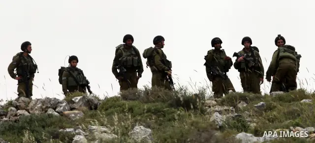 Israeli soldiers stand between Palestinian farmers and jewish settlers after clashes in Qusra village near the west bank city of Nablus, on April 29, 2012. Photo by Nedal Shtieh