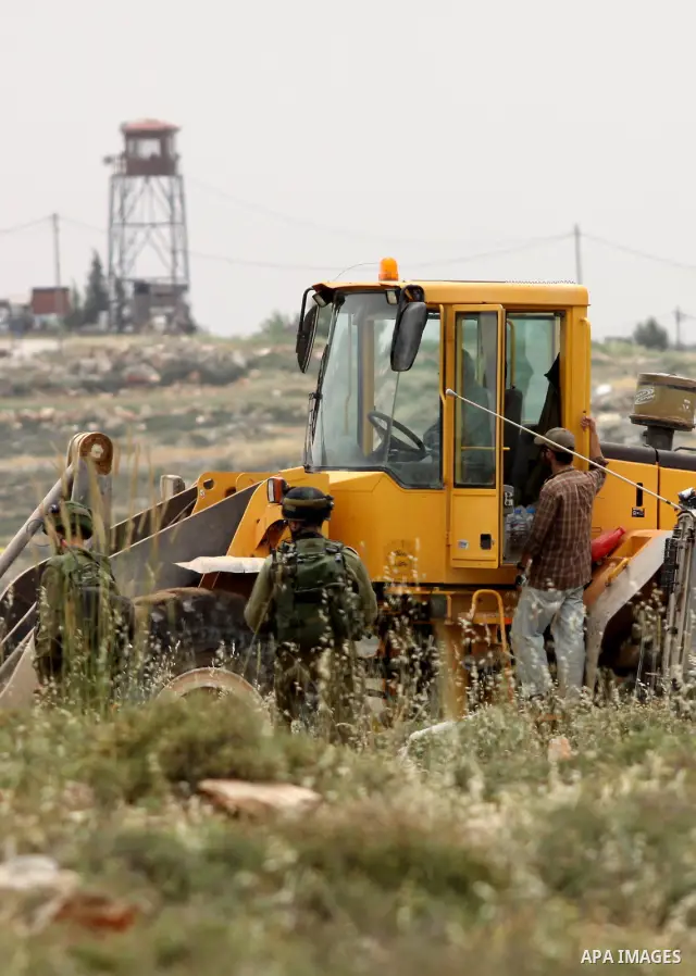 Israeli soldiers stand between Palestinian farmers and jewish settlers after clashes in Qusra village near the west bank city of Nablus, on April 29, 2012. Photo by Nedal Shtieh