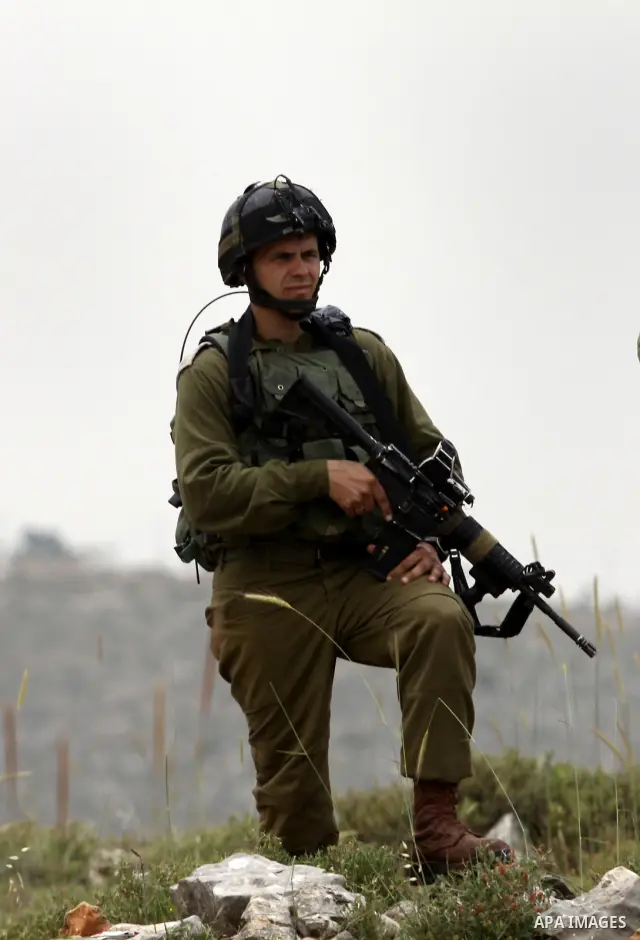 Israeli soldiers stand between Palestinian farmers and jewish settlers after clashes in Qusra village near the west bank city of Nablus, on April 29, 2012. Photo by Nedal Shtieh