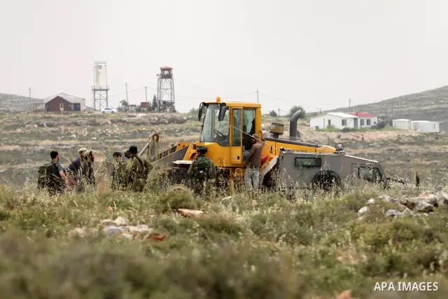 Israeli soldiers stand between Palestinian farmers and jewish settlers after clashes in Qusra village near the west bank city of Nablus, on April 29, 2012. Photo by Nedal Shtieh