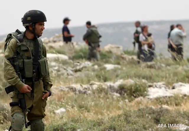 Israeli soldiers stand between Palestinian farmers and jewish settlers after clashes in Qusra village near the west bank city of Nablus, on April 29, 2012. Photo by Nedal Shtieh
