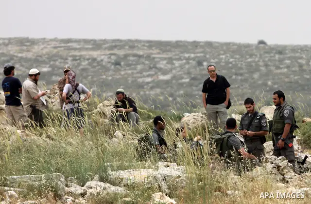 Israeli soldiers stand between Palestinian farmers and jewish settlers after clashes in Qusra village near the west bank city of Nablus, on April 29, 2012. Photo by Nedal Shtieh