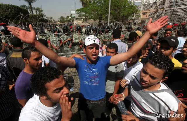 Egyptian protesters march back to the Ministry of Defense after battling thugs in the nearby streets of the Abasseya neighborhood of Cairo for several hours on Sunday, April 29, 2012. The army had mover back their securi...