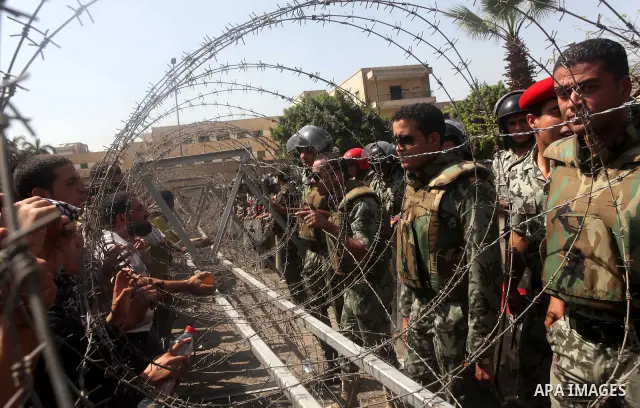 Egyptian protesters march back to the Ministry of Defense after battling thugs in the nearby streets of the Abasseya neighborhood of Cairo for several hours on Sunday, April 29, 2012. The army had mover back their securi...