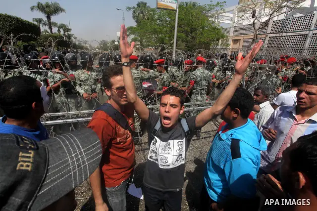 Egyptian protesters march back to the Ministry of Defense after battling thugs in the nearby streets of the Abasseya neighborhood of Cairo for several hours on Sunday, April 29, 2012. The army had mover back their securi...