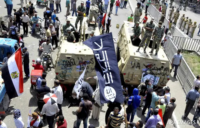 Egyptian protesters march back to the Ministry of Defense after battling thugs in the nearby streets of the Abasseya neighborhood of Cairo for several hours on Sunday, April 29, 2012. The army had mover back their securi...