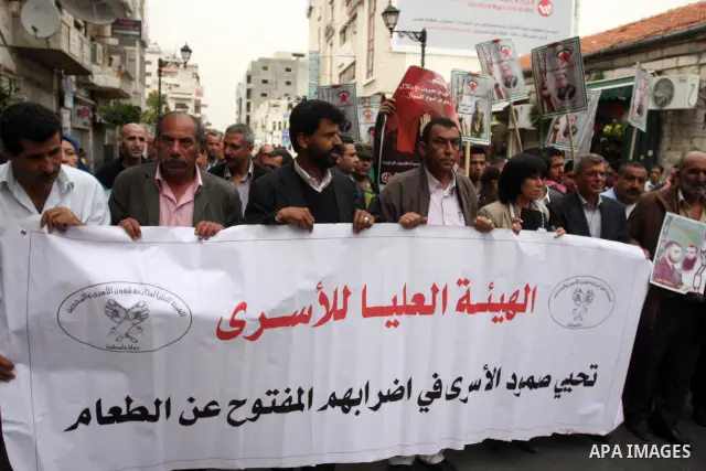 Palestinian protesters hold up banners and portraits of a prisoners jailed in Israel,during a rally in solidarity with prisoners in Israeli jails, in the West Bank city of Ramallah, April 29, 2012.Over the past week, ove...