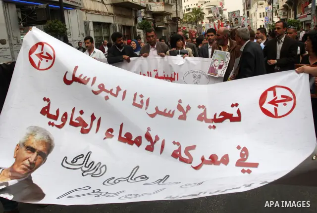 Palestinian protesters hold up banners and portraits of a prisoners jailed in Israel,during a rally in solidarity with prisoners in Israeli jails, in the West Bank city of Ramallah, April 29, 2012.Over the past week, ove...