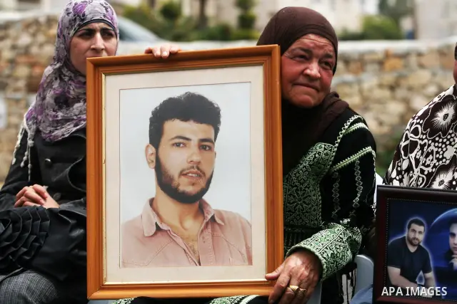 Palestinian protesters hold up banners and portraits of a prisoners jailed in Israel,during a rally in solidarity with prisoners in Israeli jails, in the West Bank city of Ramallah, April 29, 2012.Over the past week, ove...