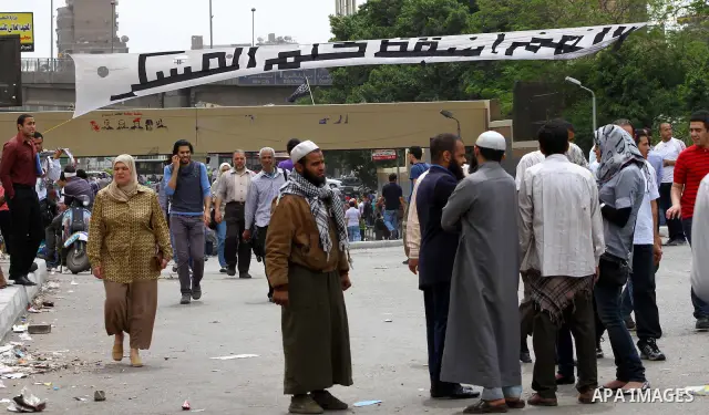 Egyptian Protesters walk near the Ministry of Defense in the Abbassiya district of Cairo April 30, 2012. Protesters continued their sit-in on April 30 after they were attacked two days earlier, which resulted in the deat...