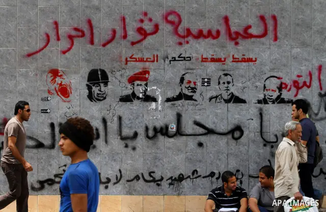 Egyptian Protesters walk near the Ministry of Defense in the Abbassiya district of Cairo April 30, 2012. Protesters continued their sit-in on April 30 after they were attacked two days earlier, which resulted in the deat...