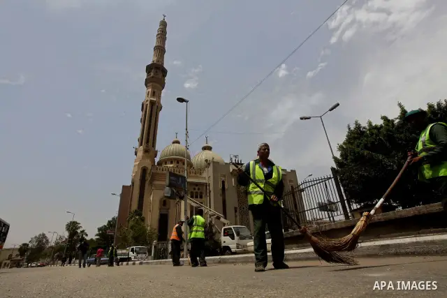 Egyptian Cleaners clean the road in the Abbassiya district of Cairo April 30, 2012. Protesters continued their sit-in on April 30 after they were attacked two days earlier, which resulted in the death of one person and t...