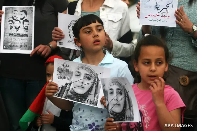 Palestinian children hold up banners and portraits of a prisoners jailed in Israel,during a rally in solidarity with prisoners in Israeli jails, in the West Bank city of Ramallah, April 30, 2012. Over the past week, over...
