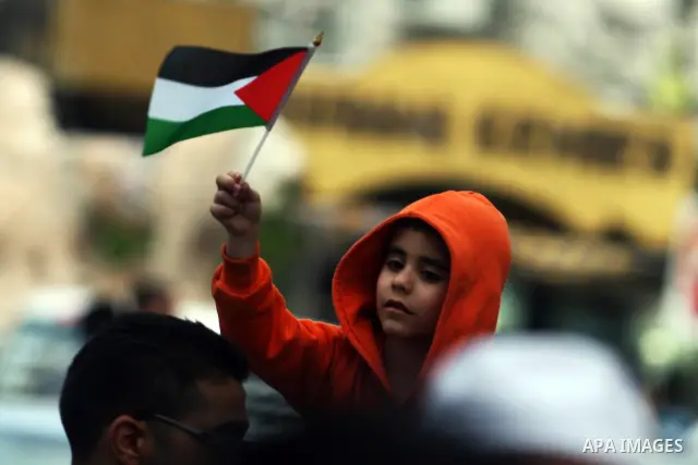 Palestinian child holds up national flagl, during a rally in solidarity with prisoners in Israeli jails, in the West Bank city of Ramallah, April 30, 2012. Over the past week, over 1,350 Palestinian prisoners have begun...