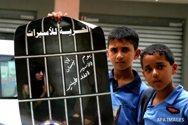 Palestinian children hold up banners and portraits of a prisoners jailed in Israel, during a Sit-in held in the neighborhood of Sheikh Jarrah, in front of the Red Cross in the West Bank city of Jerusalem, April 30, 2012....