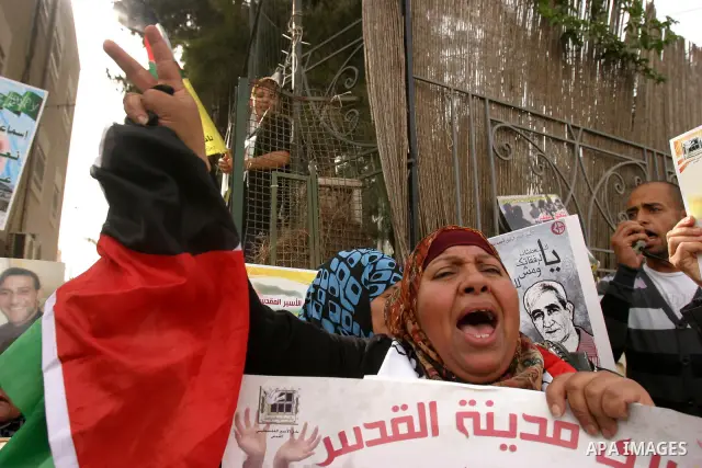 Palestinian protesters hold up banners and portraits of a prisoners jailed in Israel, during a Sit-in held in the neighborhood of Sheikh Jarrah, in front of the Red Cross in the West Bank city of Jerusalem, April 30, 201...
