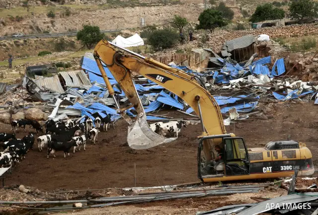 Israeli soldiers surround a bulldozer as it destroys a Palestinian farm to cows in the West Bank city of Hebron, May. 01, 2012. Reports state that tensions rose as Palestinian homes were destroyed by Israeli authorities...