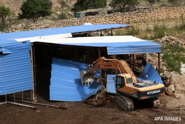 Israeli soldiers surround a bulldozer as it destroys a Palestinian farm to cows in the West Bank city of Hebron, May. 01, 2012. Reports state that tensions rose as Palestinian homes were destroyed by Israeli authorities...